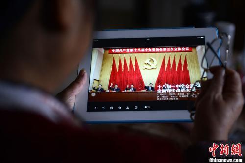 资料图：一位网友用平板电脑浏览有关中国共产党十八届三中全会的报道。<a target=